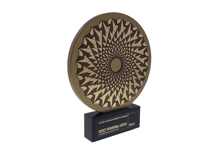 Gold geometrically patterned medallion on a black base